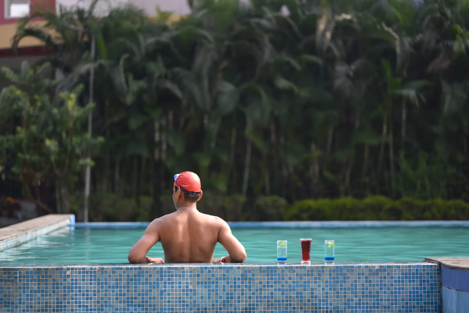 A guest relaxing poolside with drinks at Sinclairs Burdwan